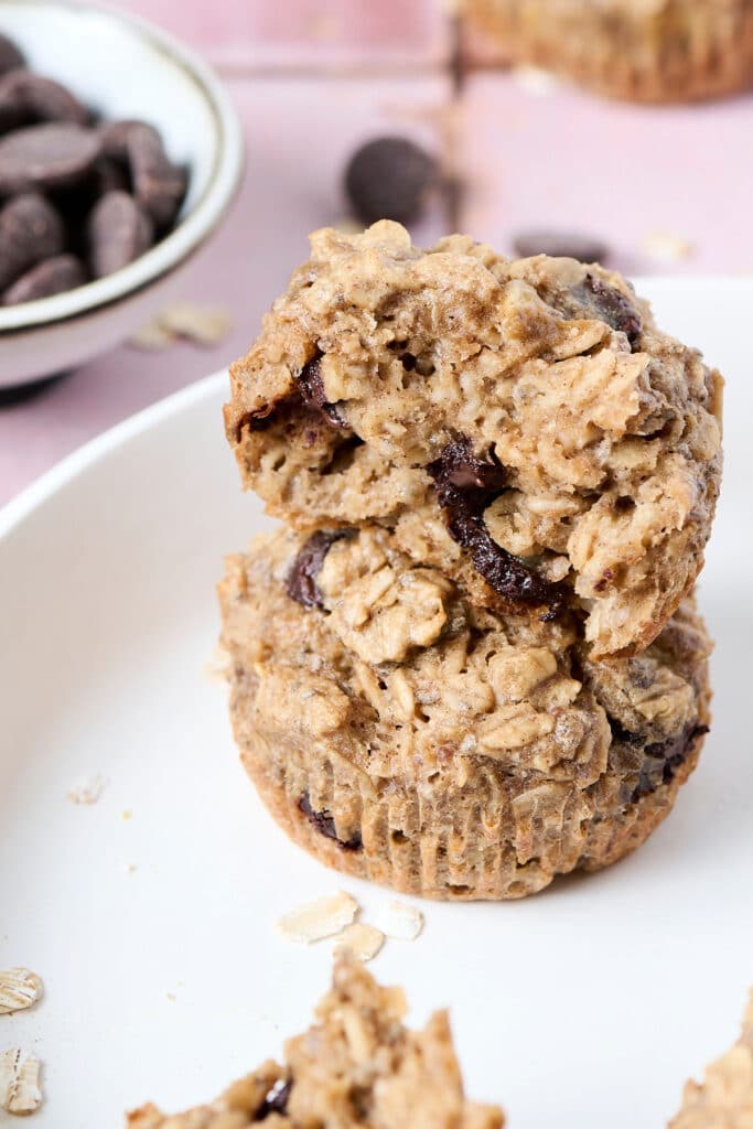two pb baked oatmeal cups stacked on top of another on white plate.