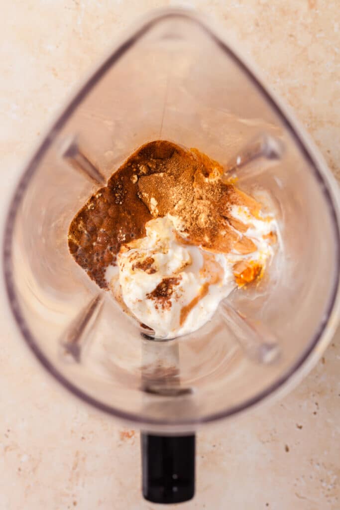 ingredients for a pumpkin smoothie in a blender.