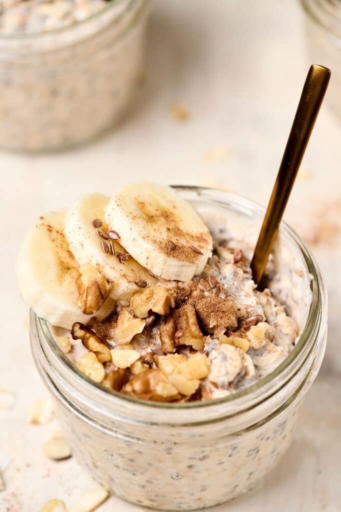 banana bread overnight oats in a small mason jar with spoon.
