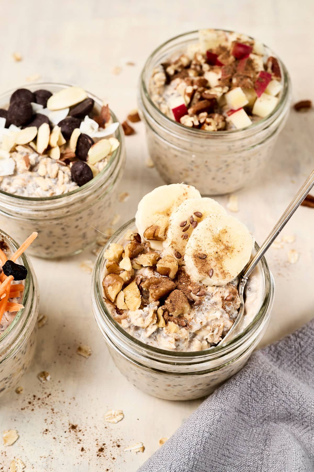 4 different pcos overnight oats in glass jars with different toppings.
