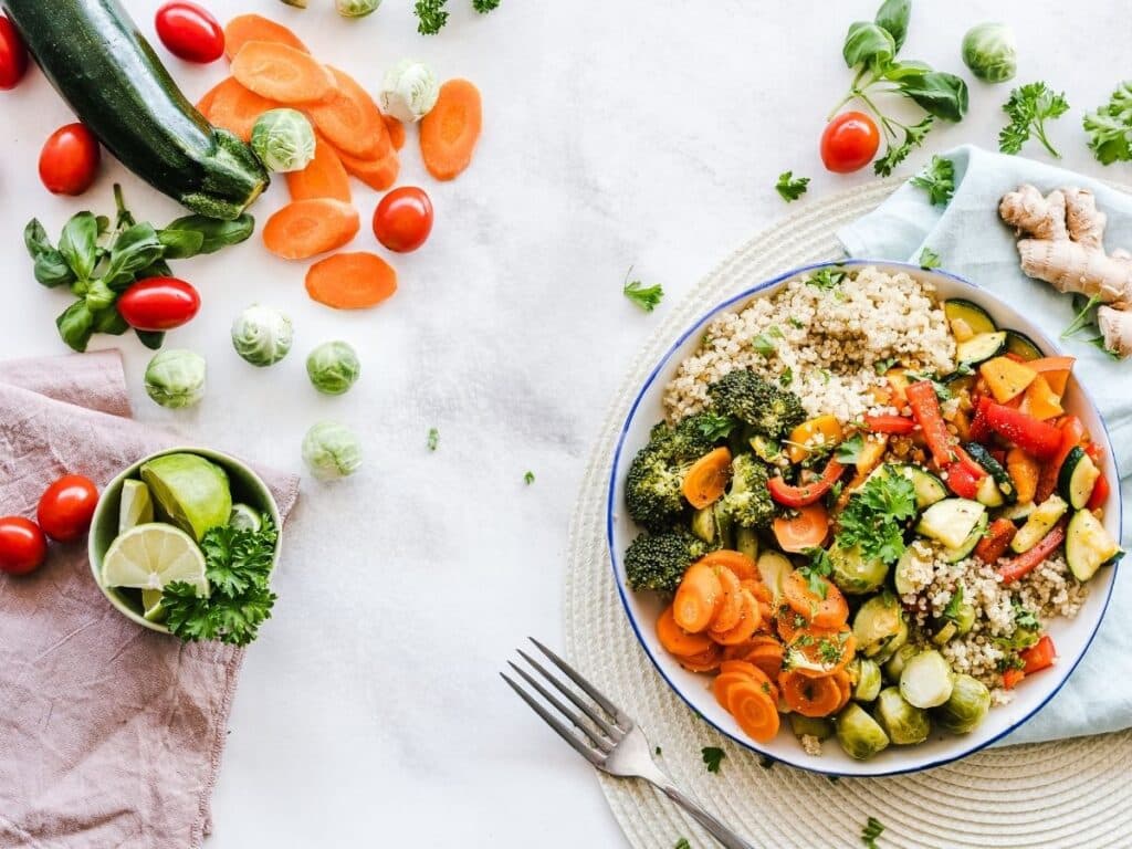 healthy meal with grains and veggies with a fork next to the plate.