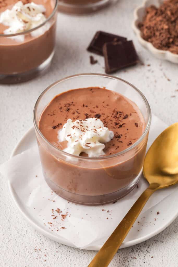 cottage cheese chocolate pudding in a glass dessert bowl with gold spoon.