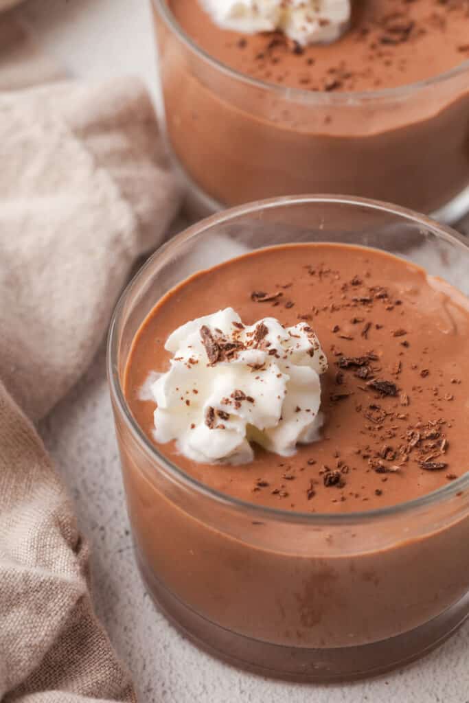 cottage cheese chocolate pudding in a glass dessert bowl with dollop of whipped cream.