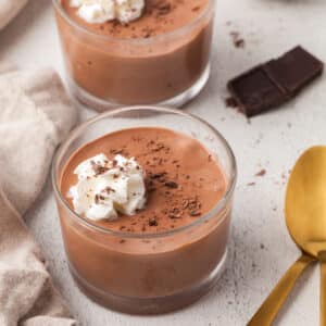 cottage cheese chocolate pudding in glass dessert bowls with dollops of whipped cream.