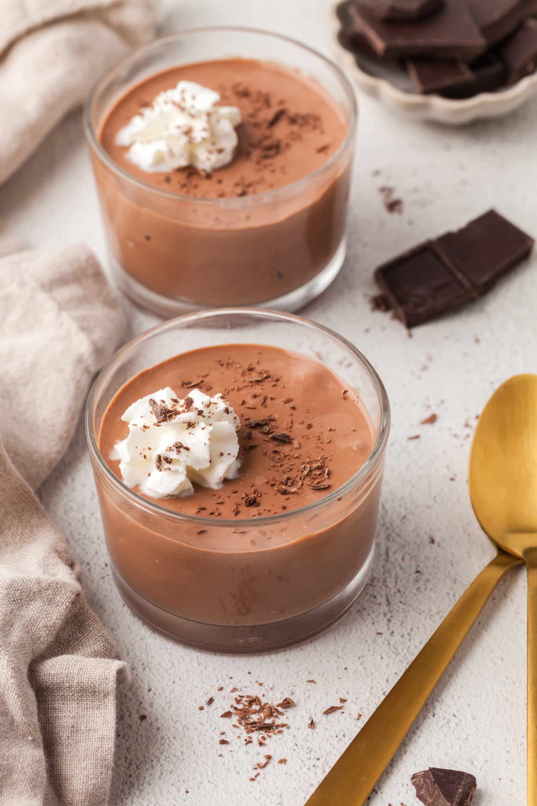 cottage cheese chocolate pudding in glass dessert bowls with dollops of whipped cream.