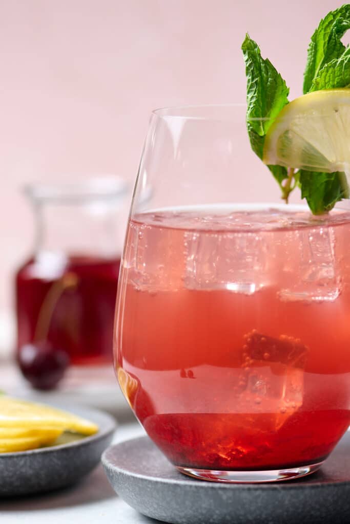 sleepy girl mocktail in a stemless wine glass with lime on the rim.