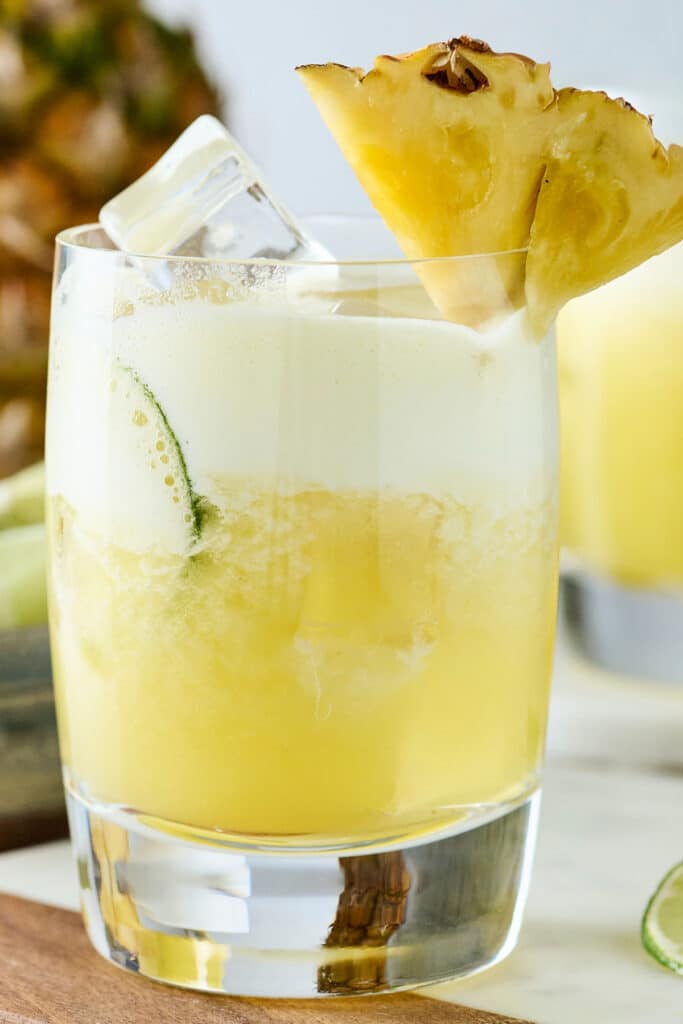 pineapple cortisol mocktail in a glass with pineapple garnish.