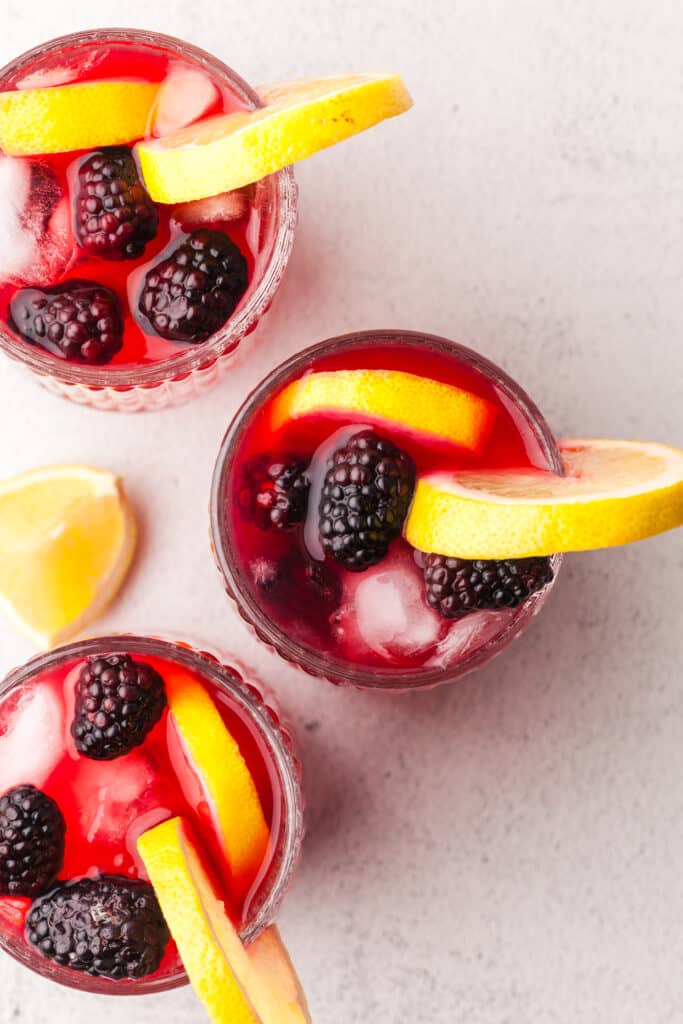 cortisol cocktails with blackberry and lemon garnish in glasses.