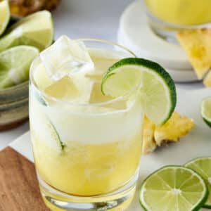 pineapple cortisol mocktail in a glass with lime garnish.