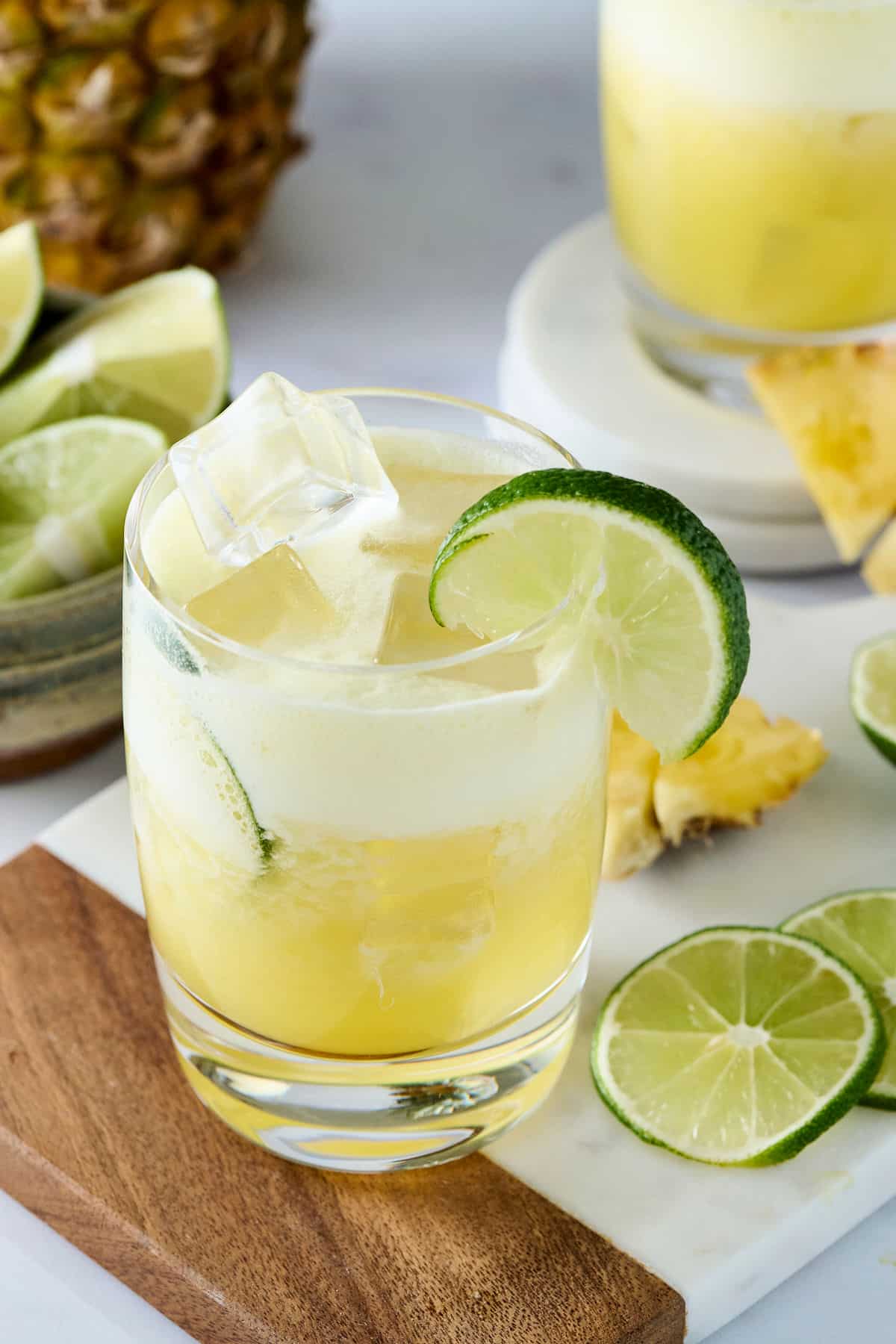 pineapple cortisol mocktail in a glass with lime garnish.