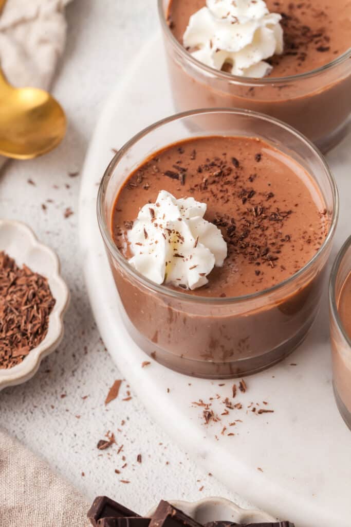 cottage cheese chocolate pudding in glass dessert bowl with a dollop of whipped cream.