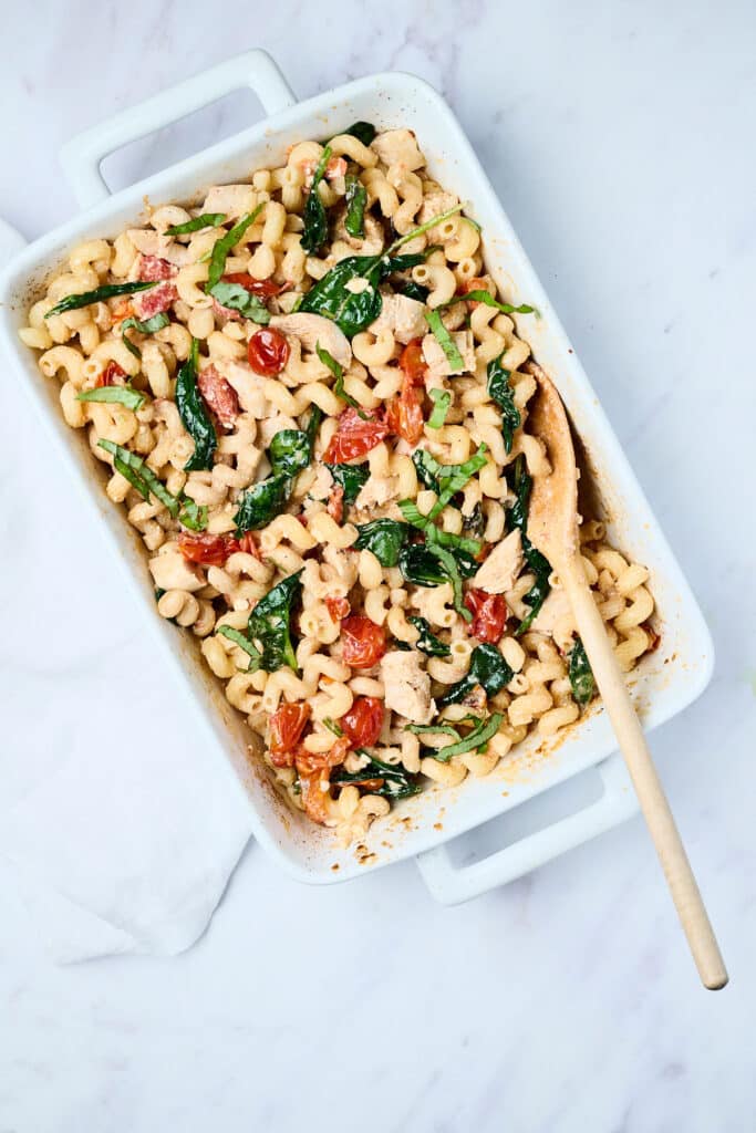 baked feta pasta in a baking dish with wooden spoon.
