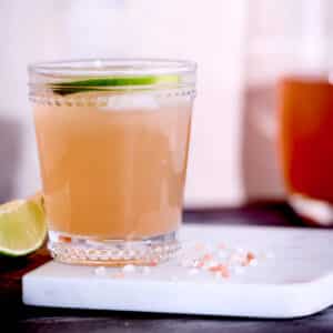 skinny cortisol cocktail in a glass on cutting board with decorative lime wedge and salt.