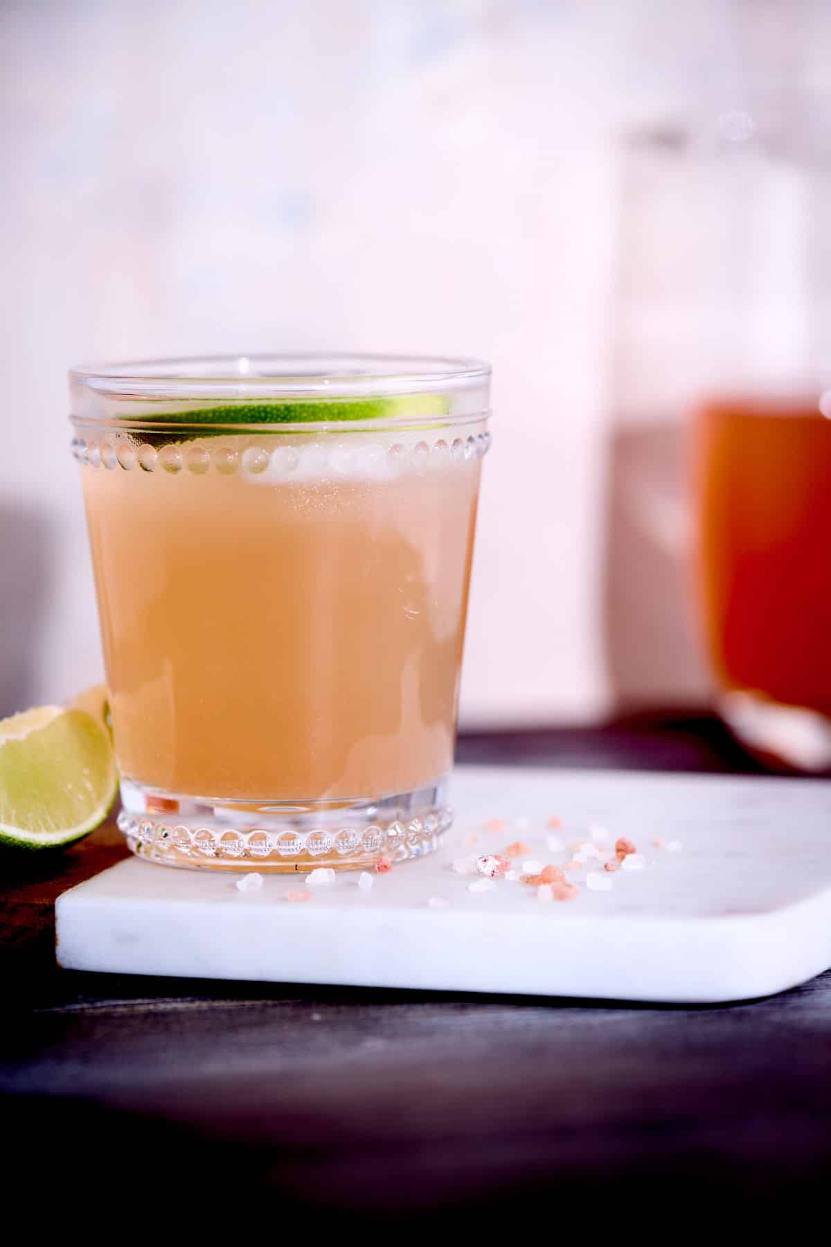 skinny cortisol cocktail in a glass on cutting board with decorative lime wedge and salt.