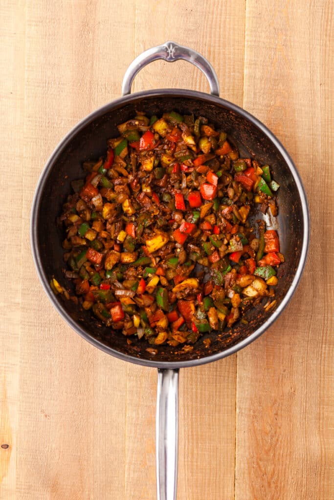 ground beef with bell peppers and spices in a large skillet.