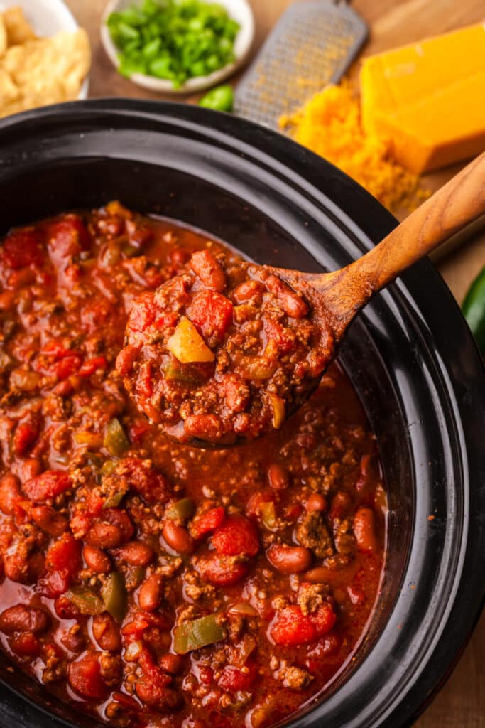 pcos chili in a crockpot with wooden spoon.