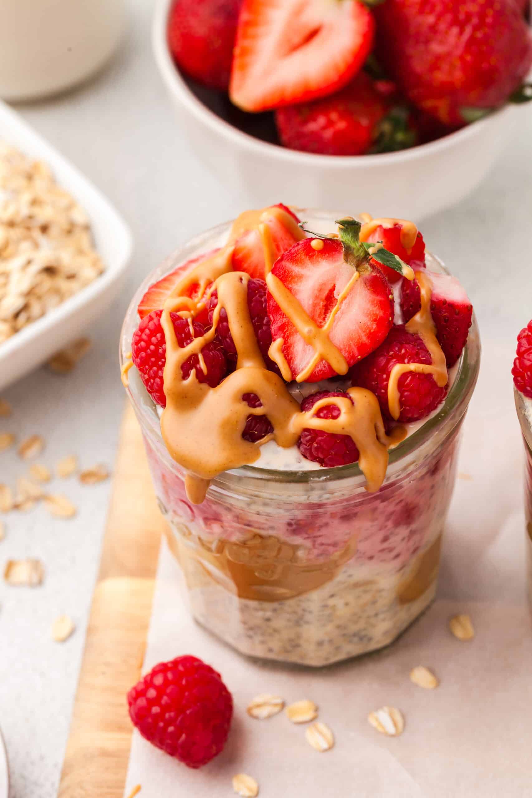 quinoa overnight oat recipe layered with berries and nut butter in glass jars.