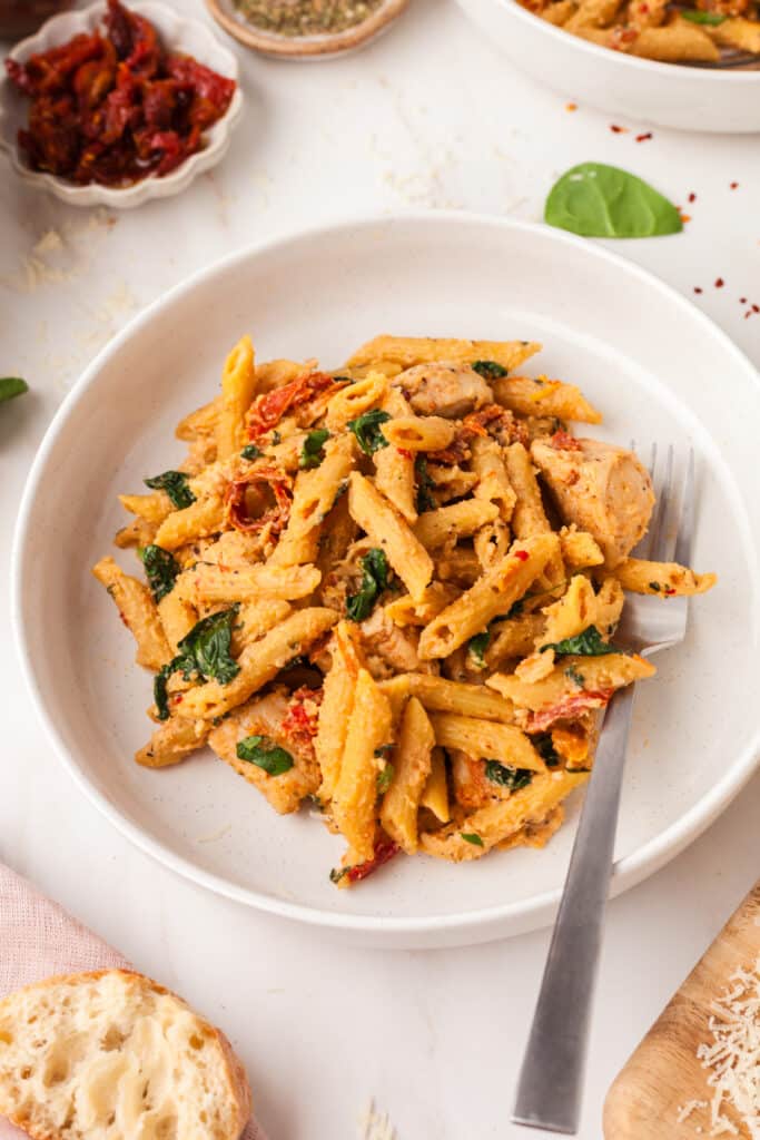 marry me chicken pasta on a white plate with a spoon.