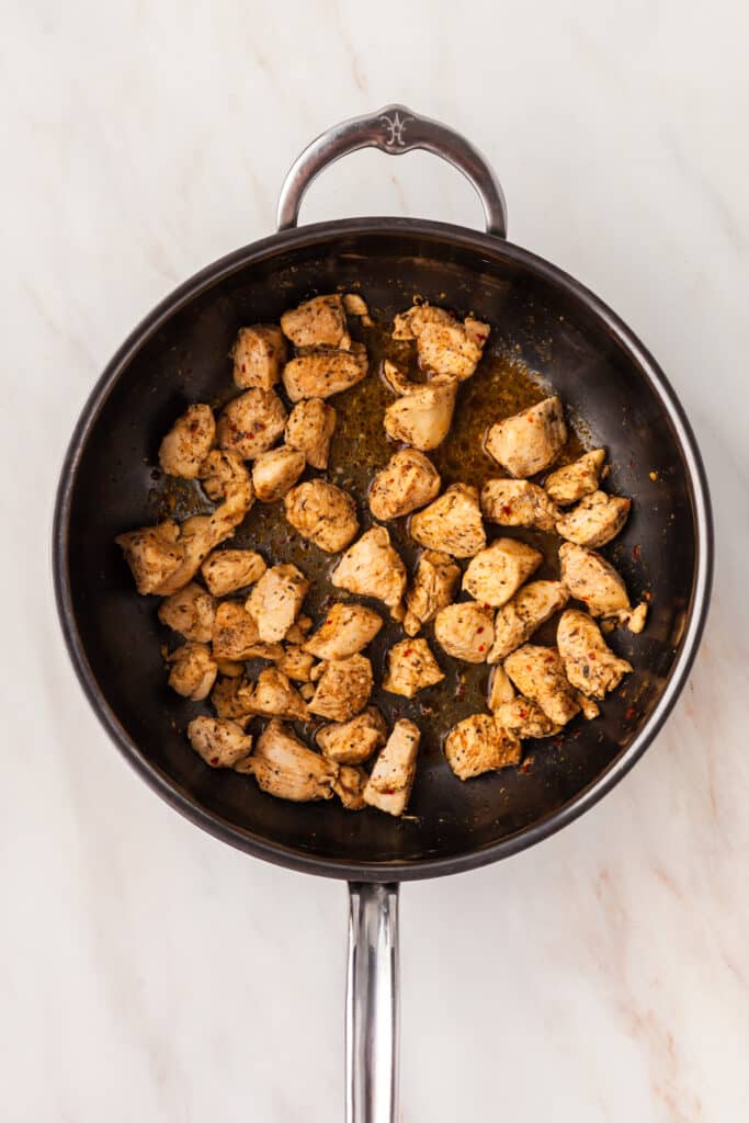 seasoned chicken cubes in a skillet.