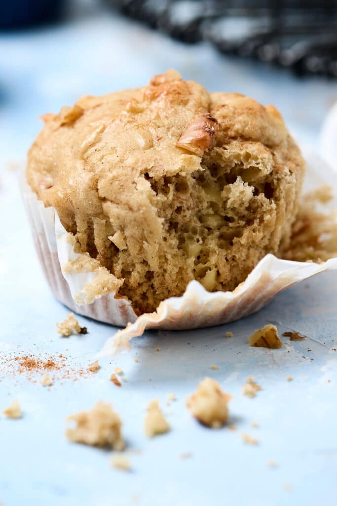 banana cottage cheese muffin with white liner partially removed and bite taken out.