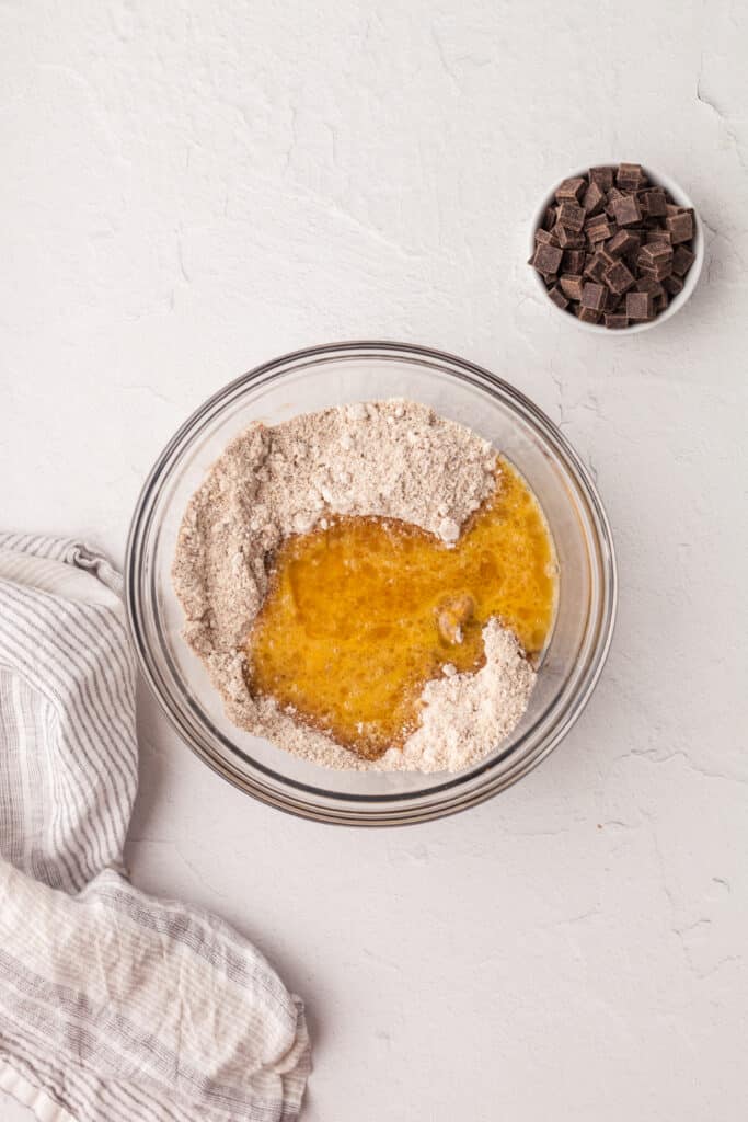 wet ingredients added to dry ingredients in a cookie recipe.