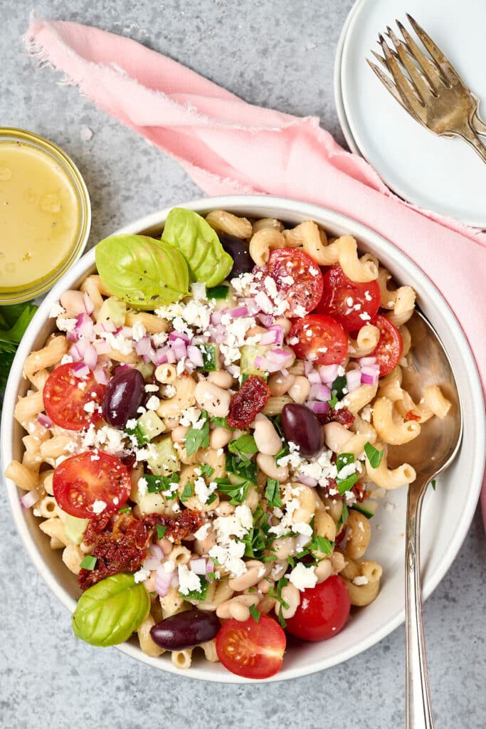 mediterranean pasta bean salad on a white plate.