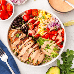 southwest chicken burrito bowl with sauce on top.