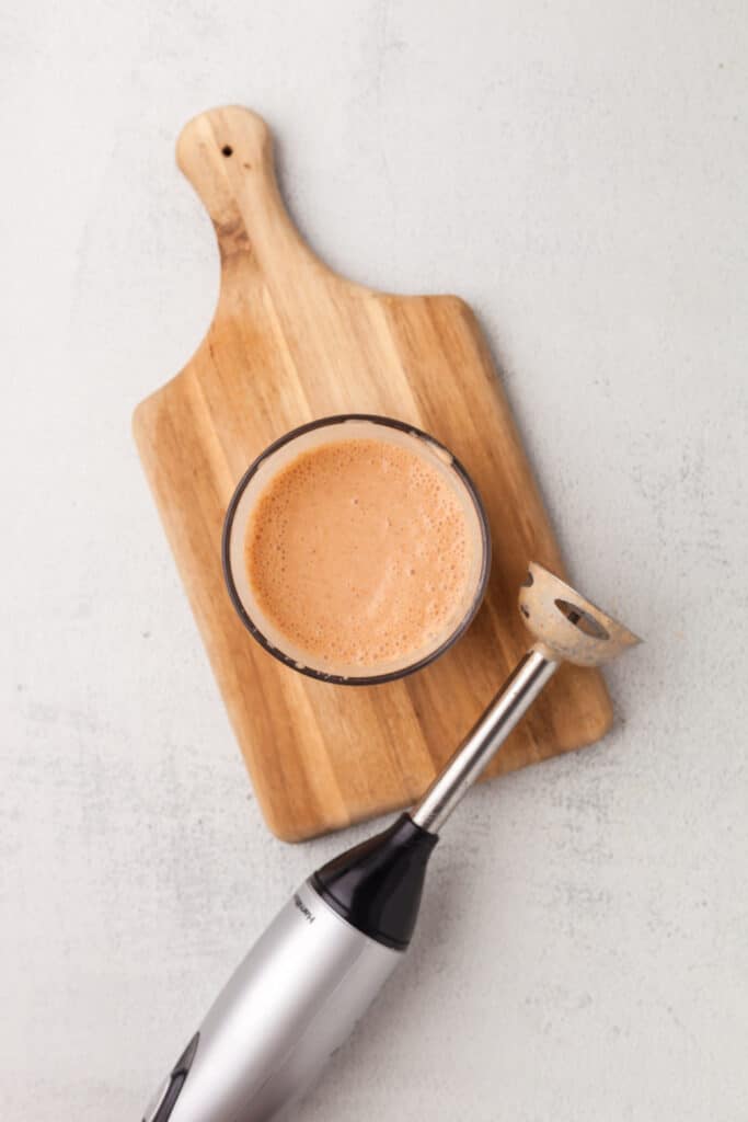southwest sauce in a bowl on cutting board with immersion blender next to it.