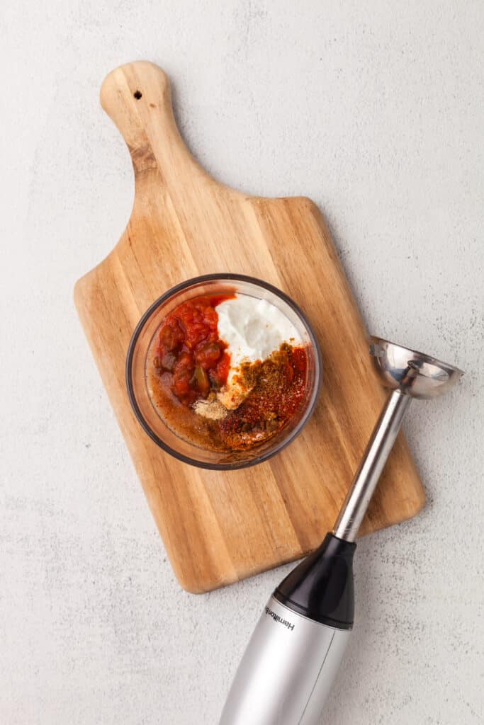 southwest sauce ingredients in a bowl with immersion blender next to it.