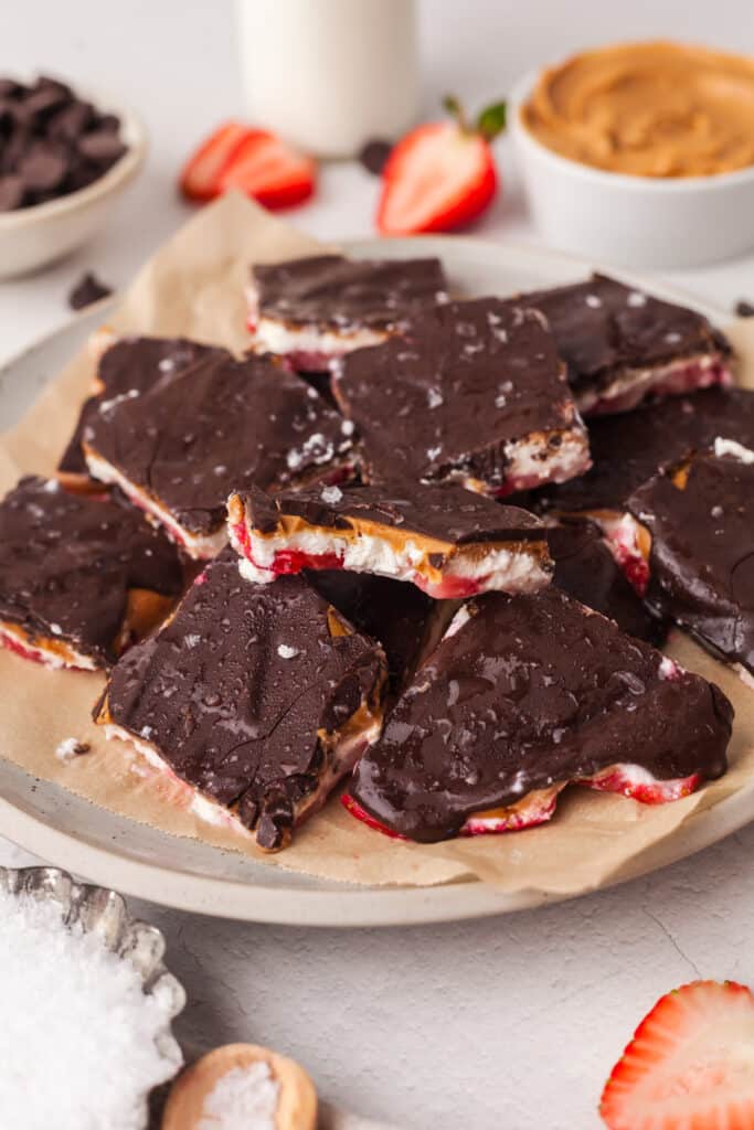 frozen cottage cheese bark pieces on a parchment lined plate.