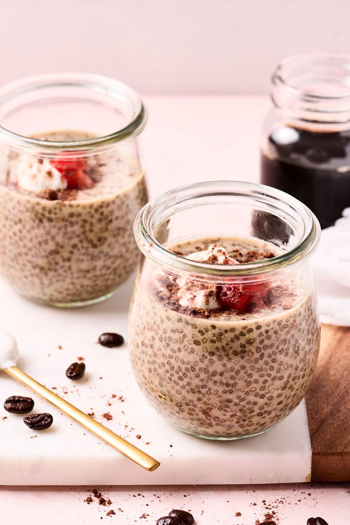 cold brew coffee chia seed pudding in glass jars on a cutting board.