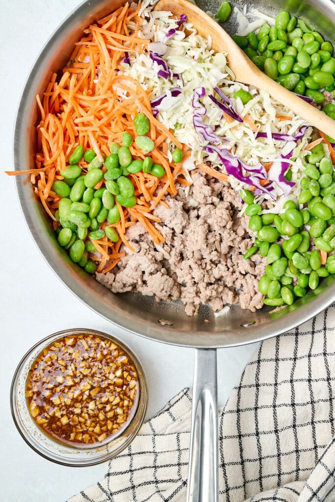 ingredients for egg roll in a bowl in a large skillet.