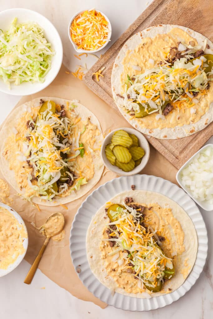 big mac wraps opened on a plate with ingredients surrounding them.