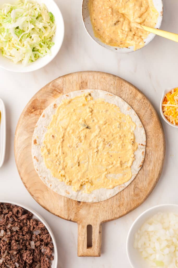 open tortilla with big mac sauce spread on it.