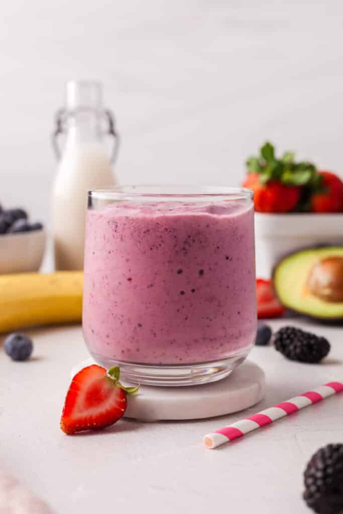 berry smoothie in a glass on a coaster.