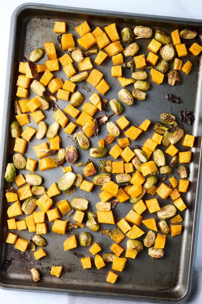 brussels sprouts and butternut squash on a baking sheet.
