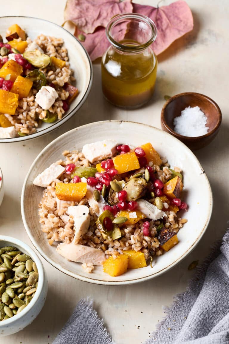 harvest grain bowl in a white bowl with ingredients around it.