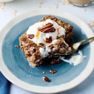 carrot cake baked oats serving on a blue plate with a fork.