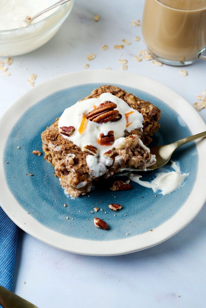 carrot cake baked oats serving on a blue plate with a fork.