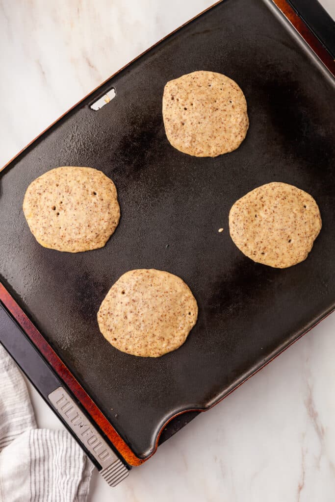 pcos pancake batter cooking on a griddle.