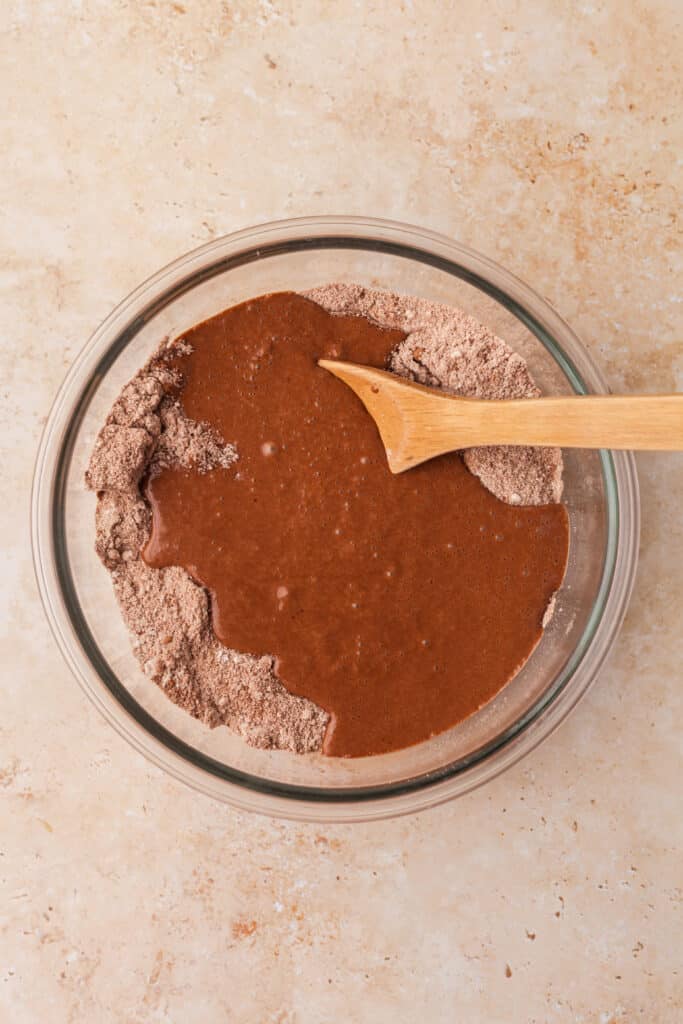 wet ingredients being mixed with dry ingredients for pcos brownies.