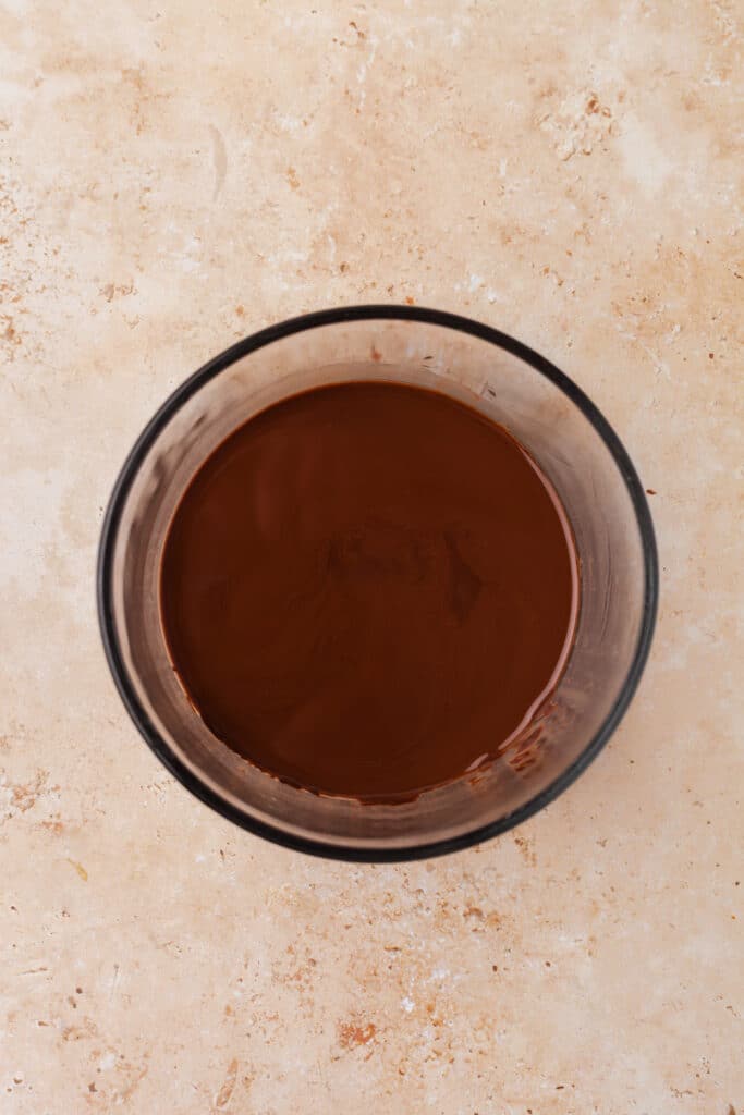 melted dark chocolate in a clear bowl.