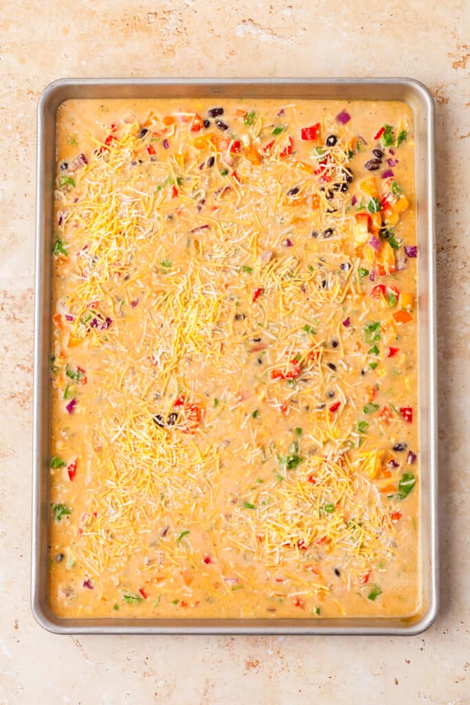 veggies and raw egg mixture on a sheet pan.
