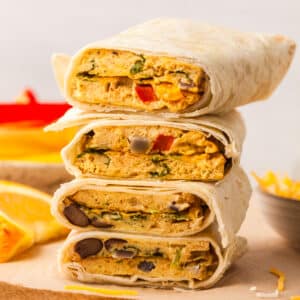 sheet pan egg burritos in tortillas stacked on top of each other.