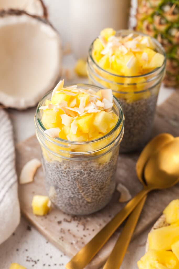 pcos chia pudding in a jar topped with pineapple and coconut shreds.