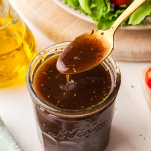 pcos friendly maple balsamic dressing In a mason jar with a spoonful on top.