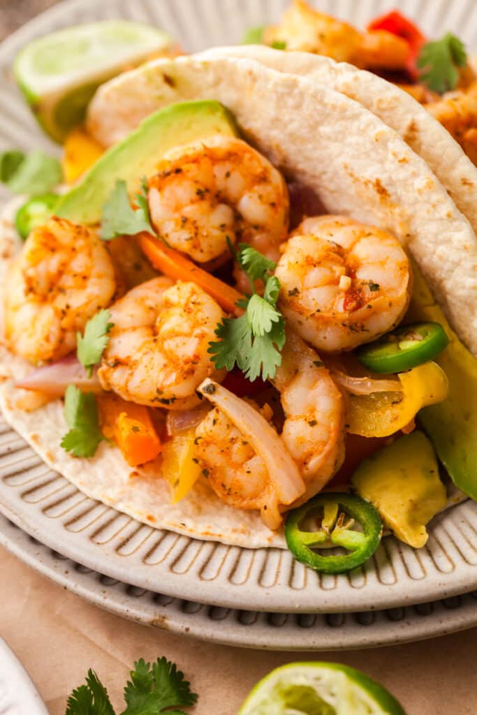 shrimp fajitas in a taco with cilantro and jalapenos.