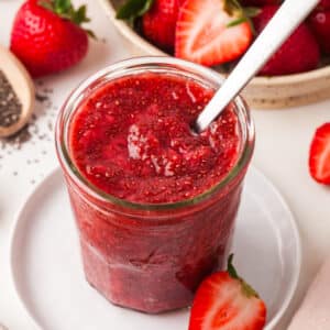chia seed jam in a mason jar with spoon inserted.