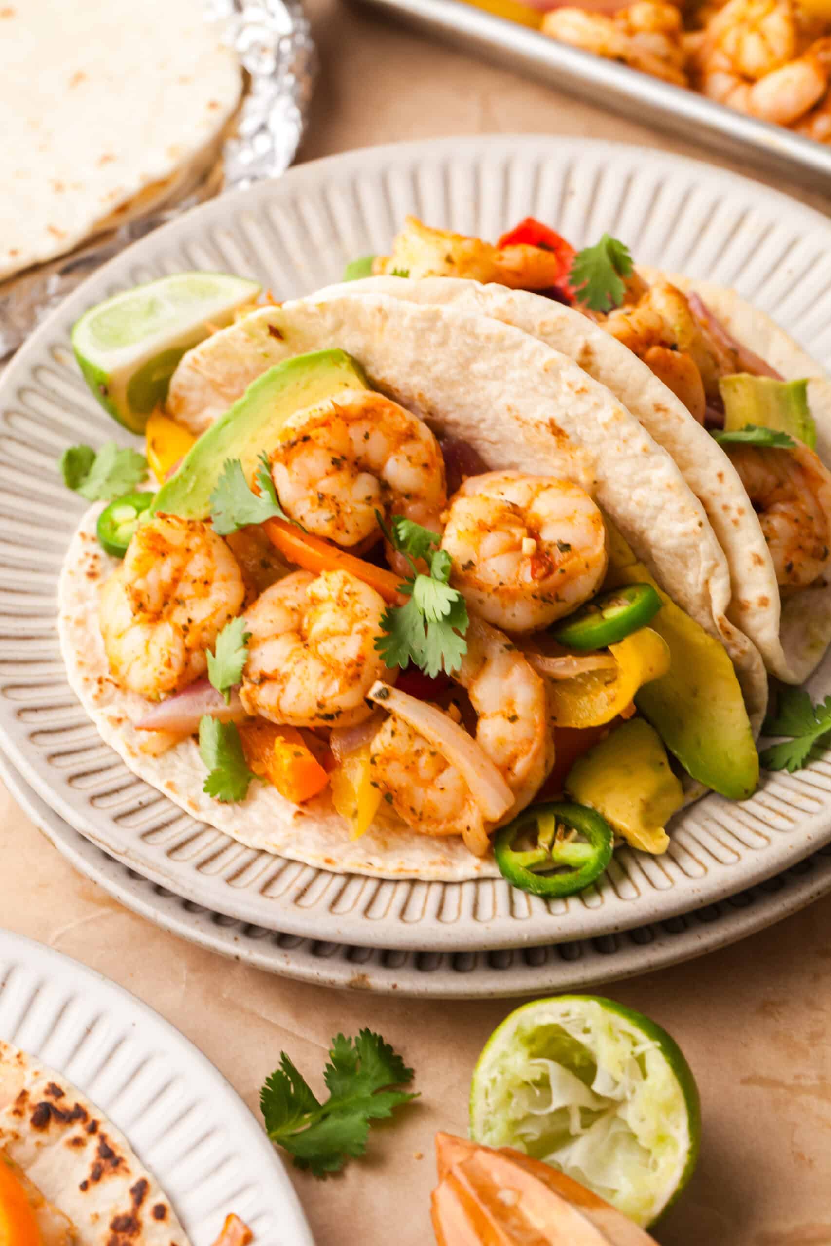 shrimp fajitas in tacos with cilantro and jalapenos.