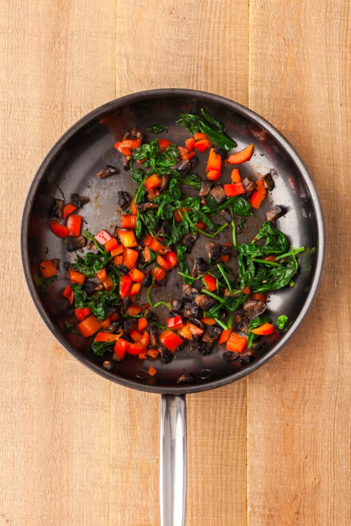 red pepper and spinach in a fry pan.